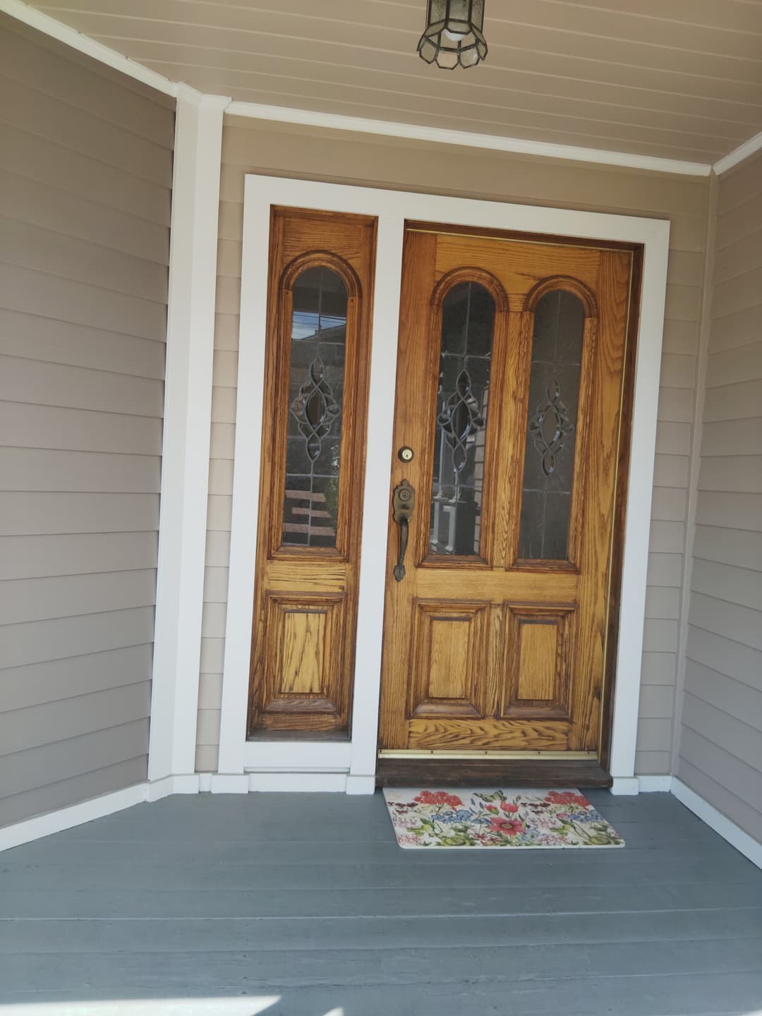 Front entry with stained wooden double doors and freshly painted exterior siding
